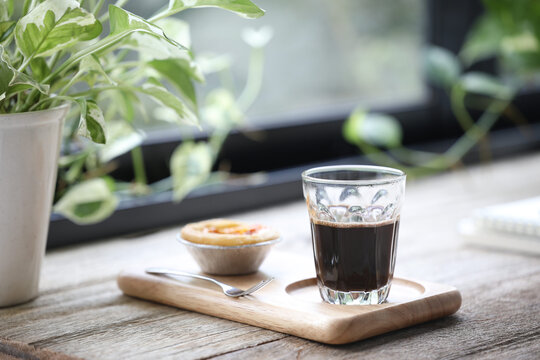 Coffee glass cup and Egg tart dessert on wooden tray