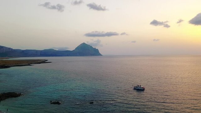 Baia Santa Margherita in Sicily from tourist boat to coast at sunset. Aerial panning