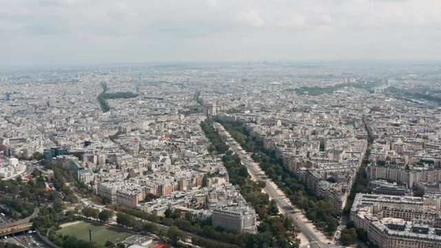 Wide slider drone shot of Arc de Triomphe and surrounding metropolitan Paris
