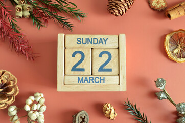 March 22, Cover design with calendar cube, pine cones and dried fruit in the natural concept.