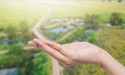 hand facing up and blurred nature background.