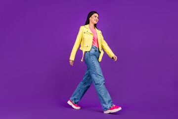 Fototapeta na wymiar Profile side photo of young millennial lady walk empty space stylish outfit isolated over violet color background