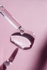 Pipette close-up on a light pink background in soft focus. Beautiful shadow in the sunlight. Skincare products , natural cosmetic. Beauty concept for face and body care
