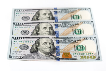 One hundred dollar bills are creatively laid out. Beautiful original cash flow. One hundred bucks as a background on a white background in high resolution.