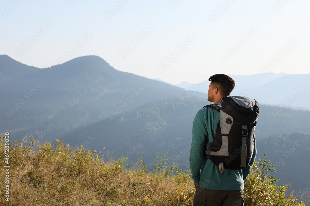 Canvas Prints Tourist with backpack in mountains on sunny day, back view. Space for text