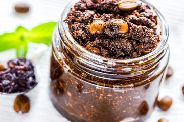 Homemade cosmetics with coffee scrub on white desk background