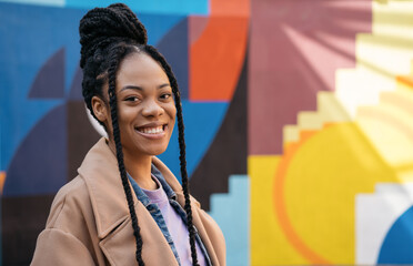 Portrait of beautiful smiling African American woman with stylish hairstyle looking at camera...