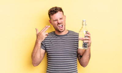 young handsome man looking unhappy and stressed, suicide gesture making gun sign. water concept