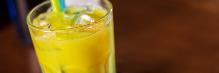 cocktail drink with blue curacao and orange juice and straw panorama