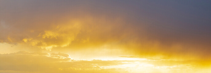 Panorama of the sky at sunset, the beautiful color of the clouds in the rays of the sun.