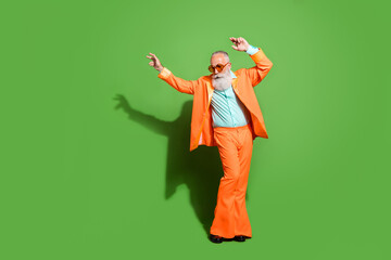 Full length body size view of attractive elegant grey-haired man dancing wearing specs isolated over bright green color background