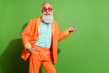 Portrait of attractive cheerful imposing man resting good mood having fun holiday isolated over vibrant green color background