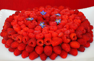 Vegan almond cake covered with fresh red raspberries