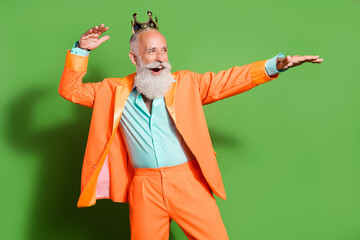 Portrait of attractive cheerful man dancing having fun celebrating holiday isolated over bright green color background