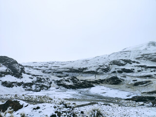 Beautiful view of snow-covered rocky mountains under dense clouds in La Cumbre