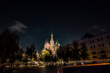 night landscape of the city with illuminated old houses, churches and a fortress wall 