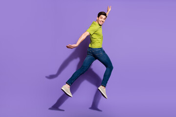 Full size profile photo of cool young brunet guy jump wear t-shirt jeans sneakers isolated on...