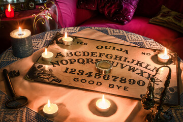 Spiritism table with a Ouija board and many lighted candles. Esoteric seance on Halloween © Fran Rodríguez