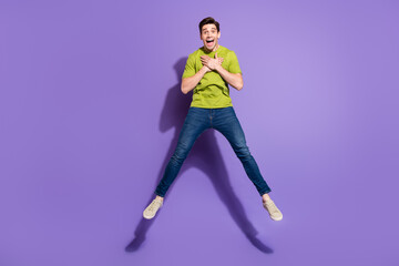 Full length body size view of attractive cheerful impressed guy jumping isolated over vivid violet purple color background