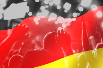 football fans supporting Germany, celebrating in stadium with raised hands against Germany flag