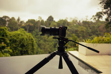 SLR camera on tripod. Filming on stormy summer day