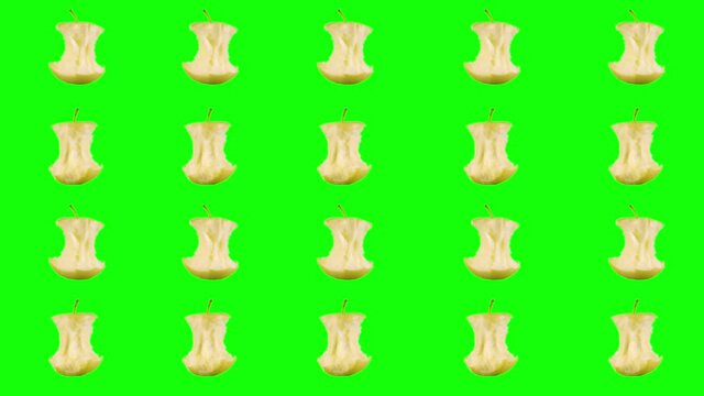 Rows, many stubs of a ripe yellow apple that have been bitten off rotate on a green chroma key background. Minimalistic animated design style. Elements concept blank background template. 