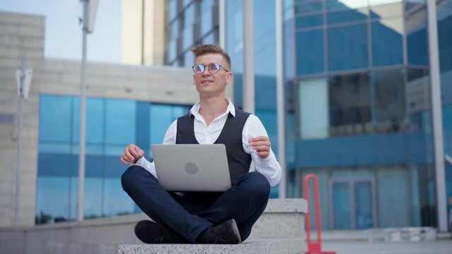 Business, Businessman Satisfied When Finished Project Work And Meditating Lotus Position Downtown Office Building Background. Mental Health Concept. Balance In Life. Freelance Caucasian Male Guy Zen