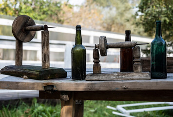 still life with a wooden table and old bottles on it against the background of the autumn sky 