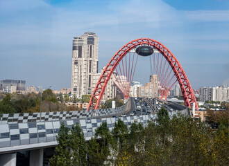 cityscape with red bridge over the river against the blue sky on a sunny day 