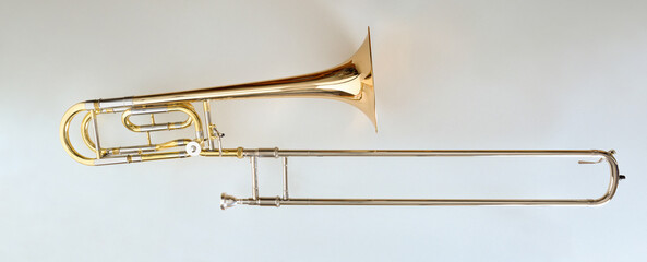 Fototapeta na wymiar Trombone with transposer mounted on a white table top view