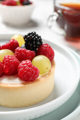 Delicious tartlet with berries on plate, closeup