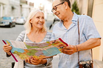 Happy senior couple of tourists exploring city