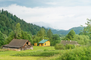 Fototapeta na wymiar Houses of a mountain village. Wooded mountains.