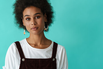 Black young woman in earrings posing and looking at camera