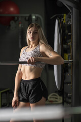 Fototapeta na wymiar Young beautiful blonde girl is engaged in the gym.