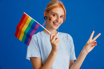 White young woman gesturing while posing with rainbow flag