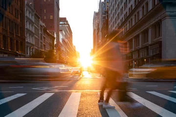 Fotobehang New York People and cars crossing the busy intersection on 5th Avenue with sunset light shining on 5th Avenue in Manhattan, New York City  © deberarr