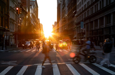 Sunlight light fades behind the buildings on 23rd Street with busy crowds of people and cars...