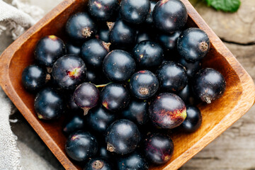 Fresh black currant. A handful of berries on a wooden table