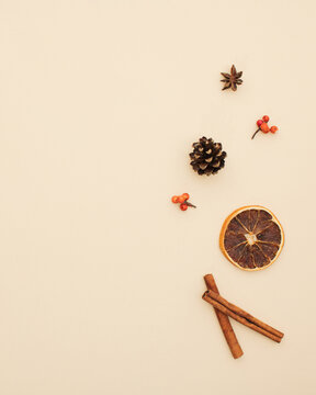 Minimal pattern made of pine cone,anis, dried orange and cinnamon stick. Minimal flat lay concept on beige background. Seasonal mood for autumn in october.