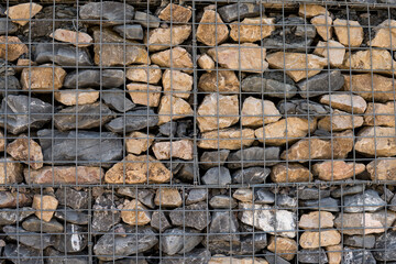 wall created from stones behind metal fence