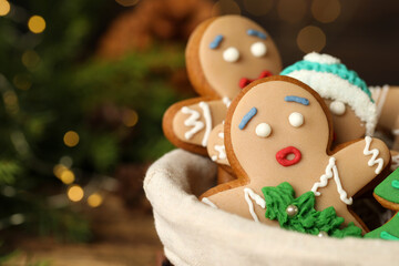 Delicious homemade Christmas cookies in bowl against blurred festive lights, closeup. Space for text