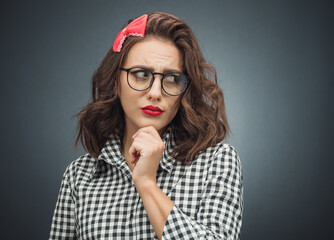 Annoyed girl looking to side over dark gray - black background.