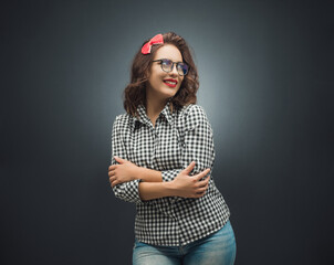 Pleasure girl looking up over dark gray - black background. retro style woman with crossed arms standing.