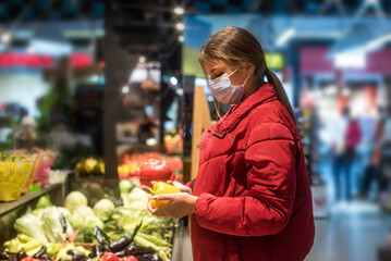 Girl wears protected mask in store. Shopping time during coronavirus outbreak. Girl in a medical mask. Quarantine and protection virus, flu, epidemic COVID-19. Coronavirus quarantine.