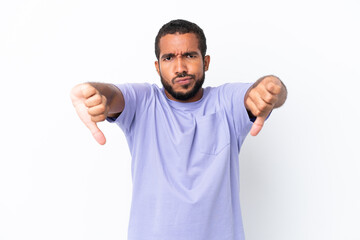 Young Ecuadorian man isolated on white background showing thumb down with two hands