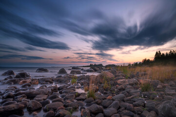Long Exposure of Magnificent Soft and colorful sunset by the seaside stone. Beautiful cloud movement
