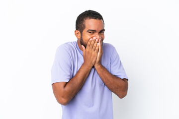 Fototapeta na wymiar Young Ecuadorian man isolated on white background happy and smiling covering mouth with hands