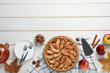 Delicious apple pie and ingredients on white wooden table, flat lay. Space for text