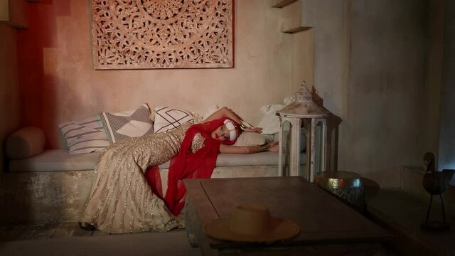 oriental princess in harem at night, beautiful woman is resting in bedroom, artistic shot